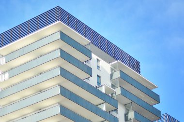 Mavi gökyüzü olan güneşli bir günde modern apartman binaları. Modern bir apartmanın cephesi