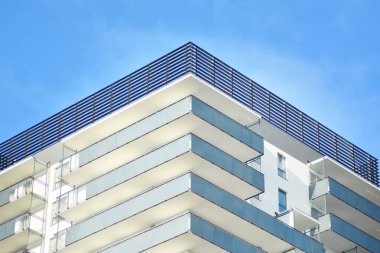 Mavi gökyüzü olan güneşli bir günde modern apartman binaları. Modern bir apartmanın cephesi