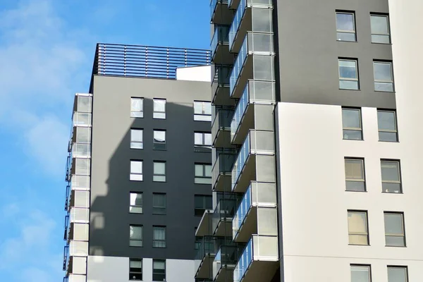 Mavi gökyüzü olan güneşli bir günde modern apartman binaları. Modern bir apartmanın cephesi