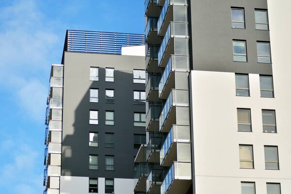Современные жилые дома в солнечный день с голубым небом. Фасад современного многоквартирного дома