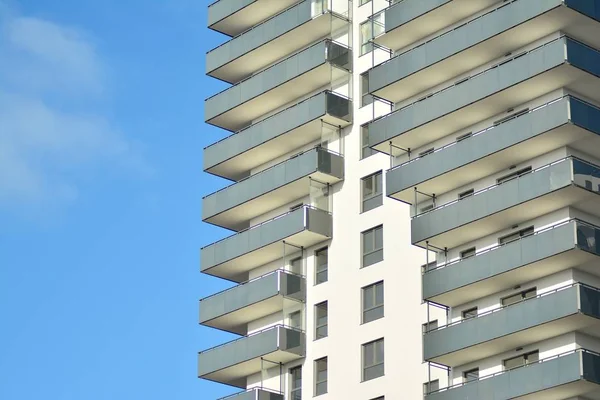 Mavi gökyüzü olan güneşli bir günde modern apartman binaları. Modern bir apartmanın cephesi