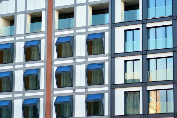 Mavi gökyüzü olan güneşli bir günde modern apartman binaları. Modern bir apartmanın cephesi