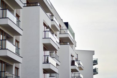 Mavi gökyüzü olan güneşli bir günde modern apartman binaları. Modern bir apartmanın cephesi