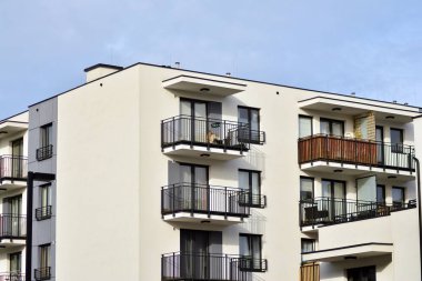 Mavi gökyüzü olan güneşli bir günde modern apartman binaları. Modern bir apartmanın cephesi