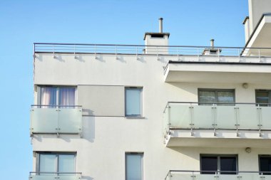 Mavi gökyüzü olan güneşli bir günde modern apartman binaları. Modern bir apartmanın cephesi