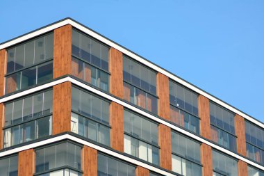Mavi gökyüzü olan güneşli bir günde modern apartman binaları. Modern bir apartmanın cephesi