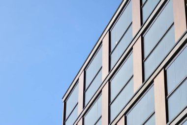 Mavi gökyüzü olan güneşli bir günde modern apartman binaları. Modern bir apartmanın cephesi