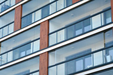 Mavi gökyüzü olan güneşli bir günde modern apartman binaları. Modern bir apartmanın cephesi