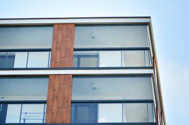 Mavi gökyüzü olan güneşli bir günde modern apartman binaları. Modern bir apartmanın cephesi