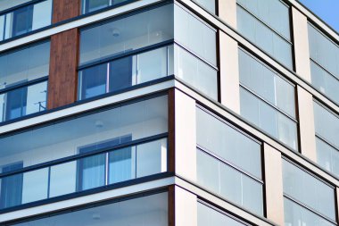 Mavi gökyüzü olan güneşli bir günde modern apartman binaları. Modern bir apartmanın cephesi