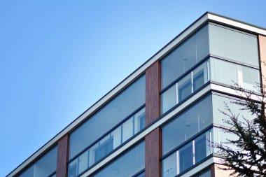 Mavi gökyüzü olan güneşli bir günde modern apartman binaları. Modern bir apartmanın cephesi