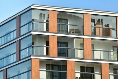 Mavi gökyüzü olan güneşli bir günde modern apartman binaları. Modern bir apartmanın cephesi