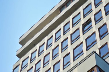 Mavi gökyüzü olan güneşli bir günde modern apartman binaları. Modern bir apartmanın cephesi