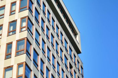 Mavi gökyüzü olan güneşli bir günde modern apartman binaları. Modern bir apartmanın cephesi