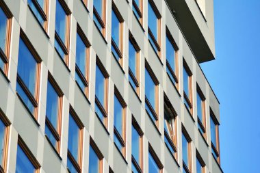 Mavi gökyüzü olan güneşli bir günde modern apartman binaları. Modern bir apartmanın cephesi