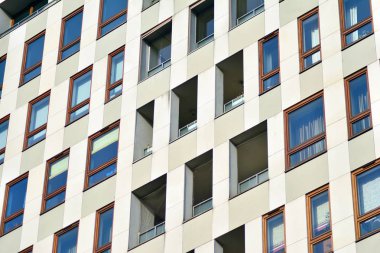 Mavi gökyüzü olan güneşli bir günde modern apartman binaları. Modern bir apartmanın cephesi