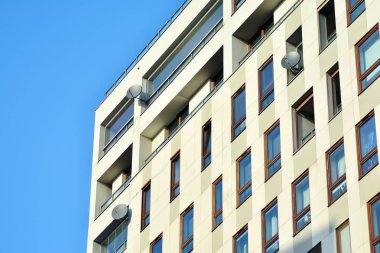 Mavi gökyüzü olan güneşli bir günde modern apartman binaları. Modern bir apartmanın cephesi