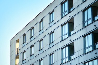 Mavi gökyüzü olan güneşli bir günde modern apartman binaları. Modern bir apartmanın cephesi