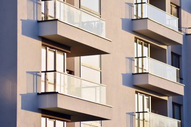 Mavi gökyüzü olan güneşli bir günde modern apartman binaları. Modern bir apartmanın cephesi