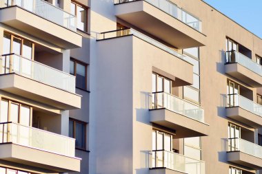 Mavi gökyüzü olan güneşli bir günde modern apartman binaları. Modern bir apartmanın cephesi