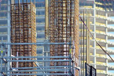 Beton sütun üzerine inşaat alanında. Vinç, araçları ve güçlendirilmiş çelik çubuklar ile gökdelen inşası