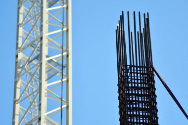 Beton sütun üzerine inşaat alanında. Vinç, araçları ve güçlendirilmiş çelik çubuklar ile gökdelen inşası