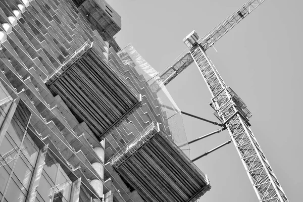 Crane attached to building. Black and white.