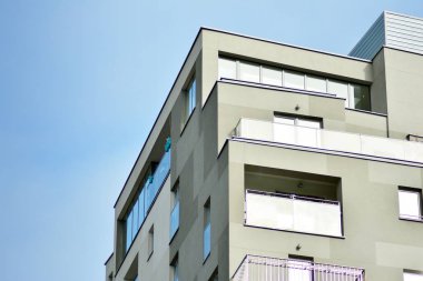 Mavi gökyüzü olan güneşli bir günde modern apartman binaları. Modern bir apartmanın cephesi