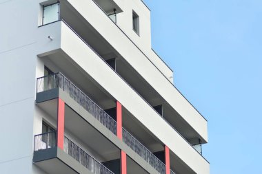 Mavi gökyüzü olan güneşli bir günde modern apartman binaları. Modern bir apartmanın cephesi