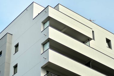 Mavi gökyüzü olan güneşli bir günde modern apartman binaları. Modern bir apartmanın cephesi