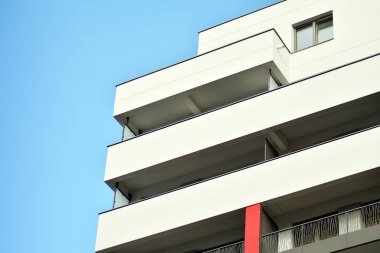 Mavi gökyüzü olan güneşli bir günde modern apartman binaları. Modern bir apartmanın cephesi