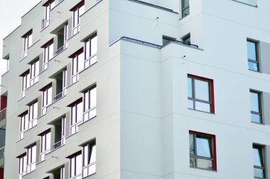 Mavi gökyüzü olan güneşli bir günde modern apartman binaları. Modern bir apartmanın cephesi