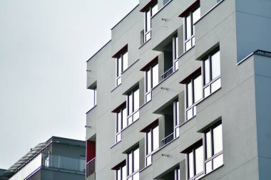 Mavi gökyüzü olan güneşli bir günde modern apartman binaları. Modern bir apartmanın cephesi