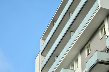 Mavi gökyüzü olan güneşli bir günde modern apartman binaları. Modern bir apartmanın cephesi