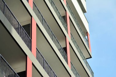 Mavi gökyüzü olan güneşli bir günde modern apartman binaları. Modern bir apartmanın cephesi