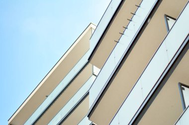 Mavi gökyüzü olan güneşli bir günde modern apartman binaları. Modern bir apartmanın cephesi