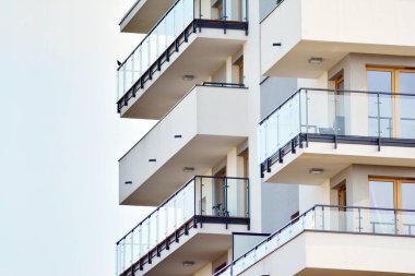 Mavi gökyüzü olan güneşli bir günde modern apartman binaları. Modern bir apartmanın cephesi