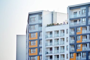 Mavi gökyüzü olan güneşli bir günde modern apartman binaları. Modern bir apartmanın cephesi