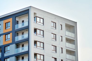 Mavi gökyüzü olan güneşli bir günde modern apartman binaları. Modern bir apartmanın cephesi