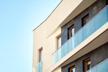 Mavi gökyüzü olan güneşli bir günde modern apartman binaları. Modern bir apartmanın cephesi
