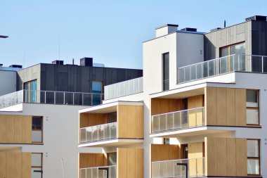 Mavi gökyüzü olan güneşli bir günde modern apartman binaları. Modern bir apartmanın cephesi
