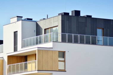 Mavi gökyüzü olan güneşli bir günde modern apartman binaları. Modern bir apartmanın cephesi