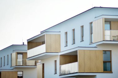 Mavi gökyüzü olan güneşli bir günde modern apartman binaları. Modern bir apartmanın cephesi