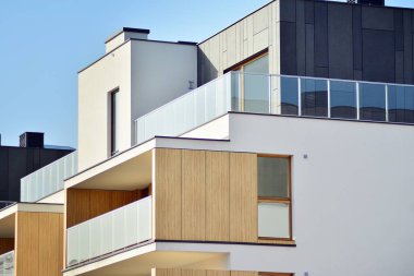 Mavi gökyüzü olan güneşli bir günde modern apartman binaları. Modern bir apartmanın cephesi