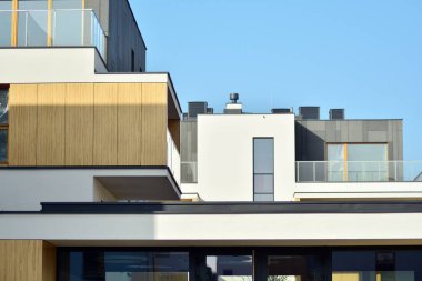 Mavi gökyüzü olan güneşli bir günde modern apartman binaları. Modern bir apartmanın cephesi