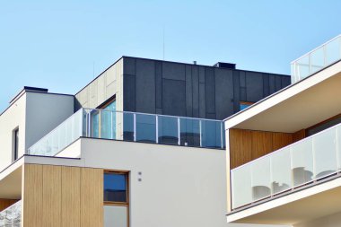 Mavi gökyüzü olan güneşli bir günde modern apartman binaları. Modern bir apartmanın cephesi