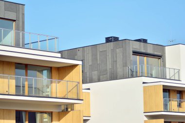 Mavi gökyüzü olan güneşli bir günde modern apartman binaları. Modern bir apartmanın cephesi