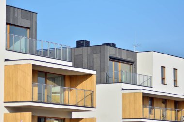 Mavi gökyüzü olan güneşli bir günde modern apartman binaları. Modern bir apartmanın cephesi
