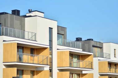 Mavi gökyüzü olan güneşli bir günde modern apartman binaları. Modern bir apartmanın cephesi