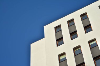 Mavi gökyüzü olan güneşli bir günde modern apartman binaları. Modern bir apartmanın cephesi